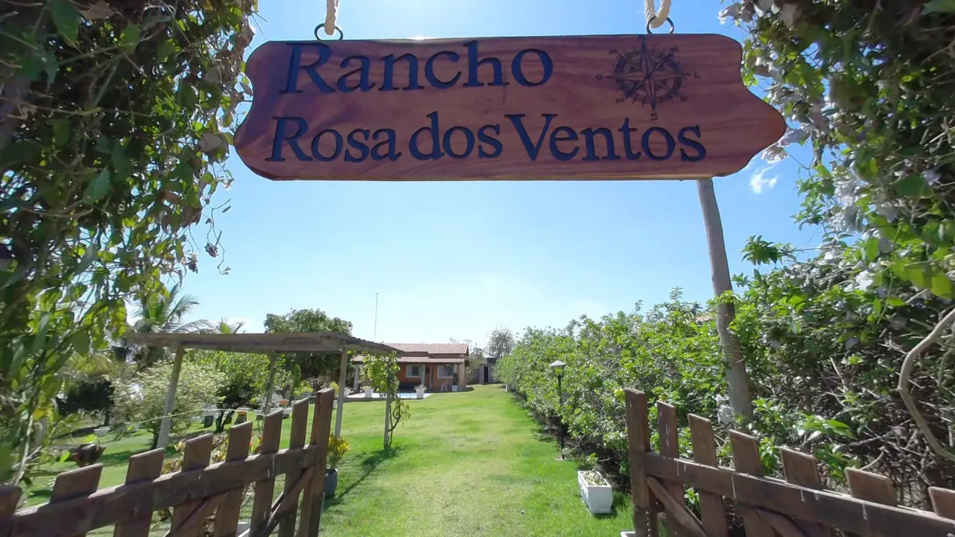 Portão do Rancho Rosa dos Ventos com a placa de madeira